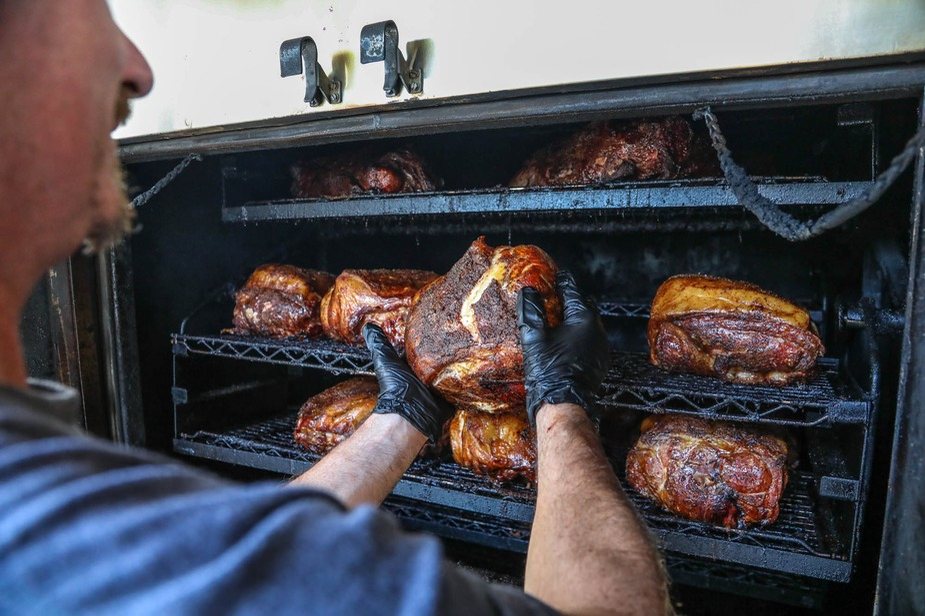 Our pitmaster pulling smoked meat off the smoker racks
