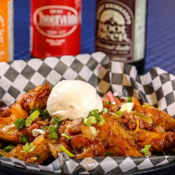 Chicken wing nachos with Moonshine BBQ sauce, cheese, green onions and sour cream